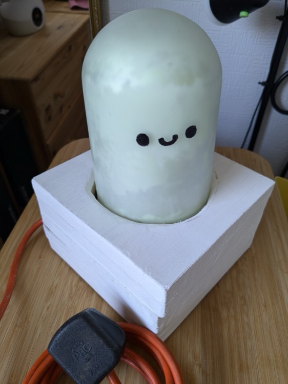 Glow: a lamp with a happy face in the daylight