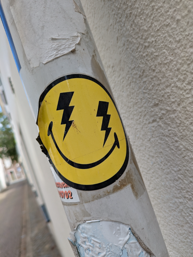 A smiley face with lightning bolt eyes