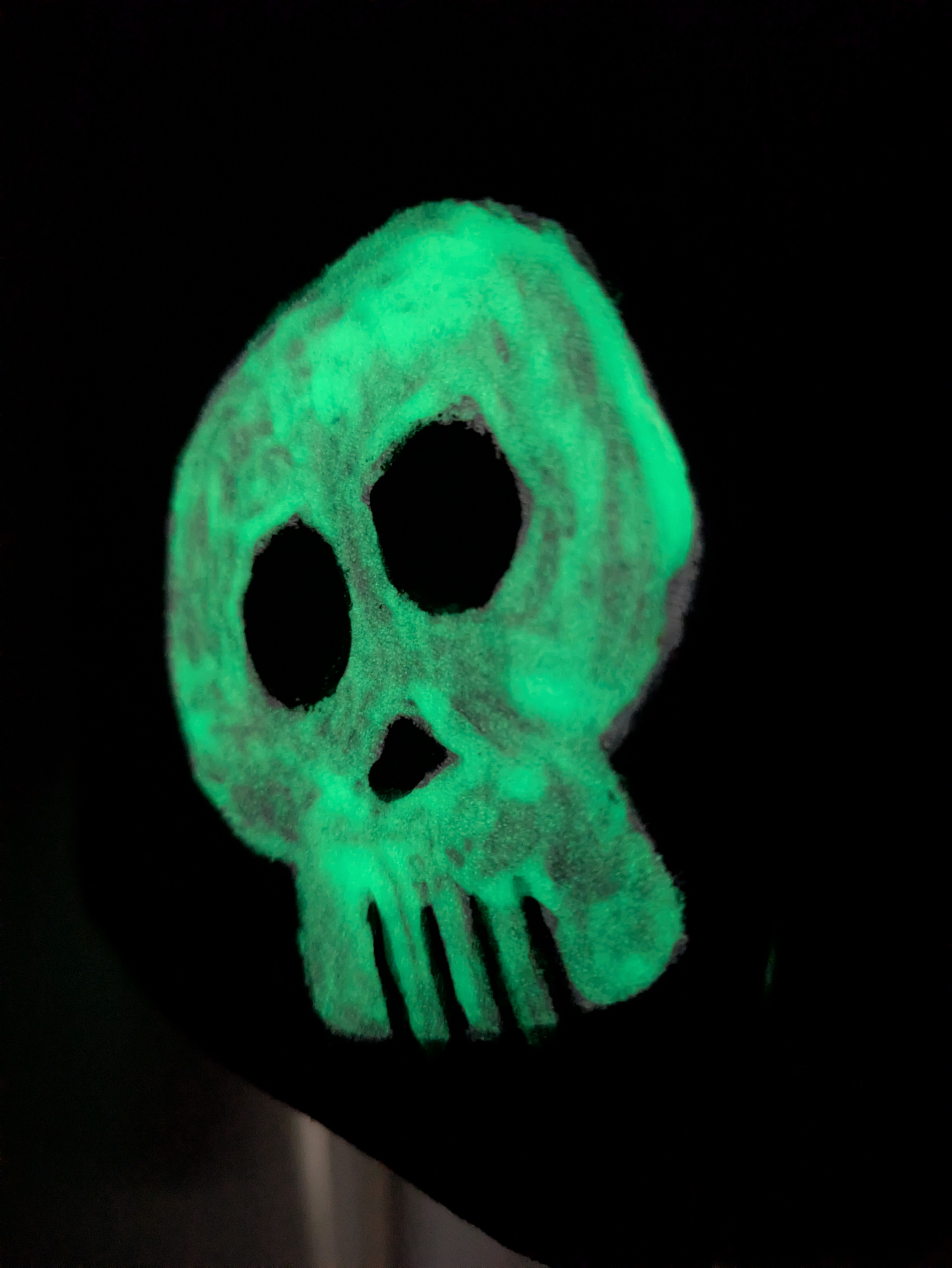 A close up of a glow-in-the-dark painted skull on black
